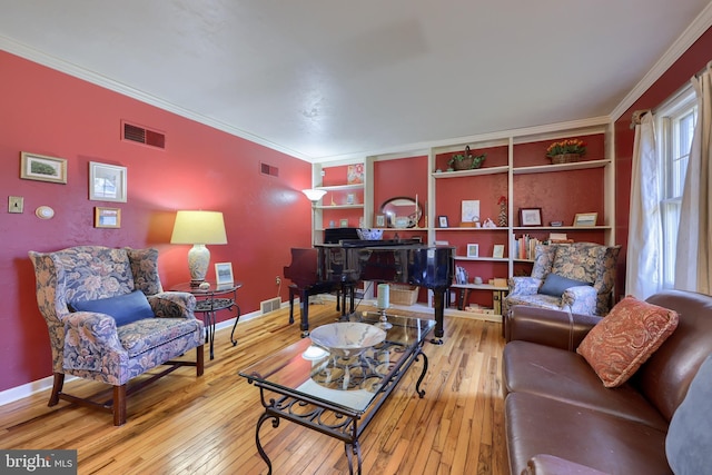 living area with visible vents, crown molding, and wood finished floors