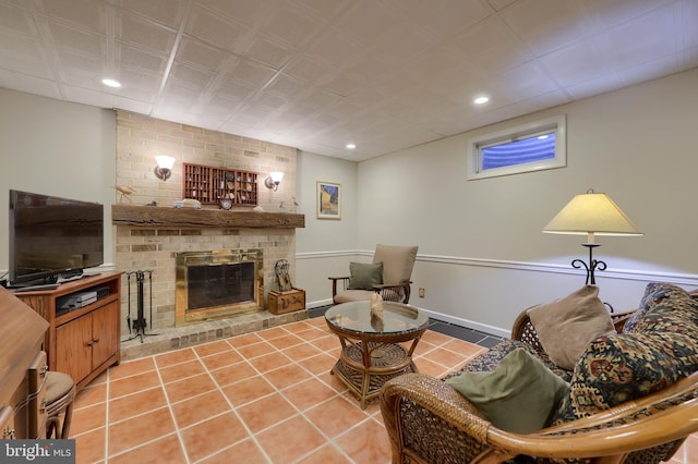 living area featuring recessed lighting, a brick fireplace, light tile patterned flooring, and baseboards