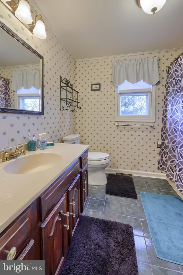 bathroom featuring toilet, ornamental molding, vanity, and wallpapered walls