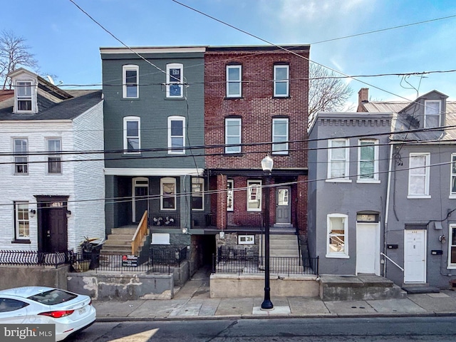 view of property with a fenced front yard and brick siding