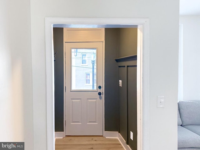 doorway with light wood-style flooring and baseboards