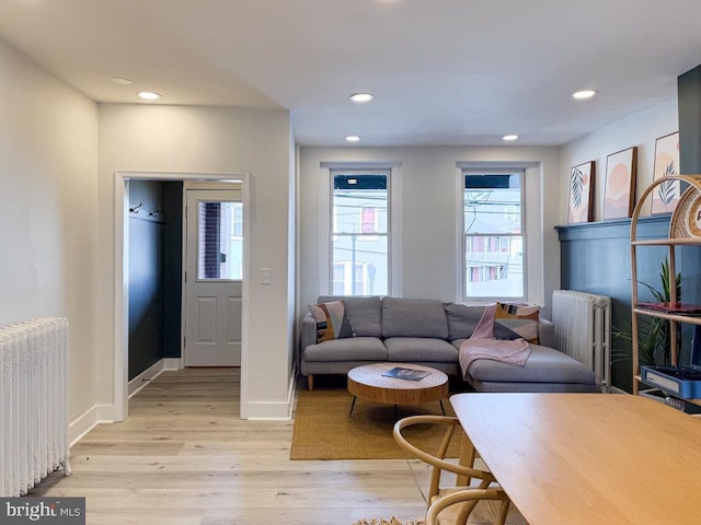 living area featuring recessed lighting, baseboards, light wood-style flooring, and radiator heating unit