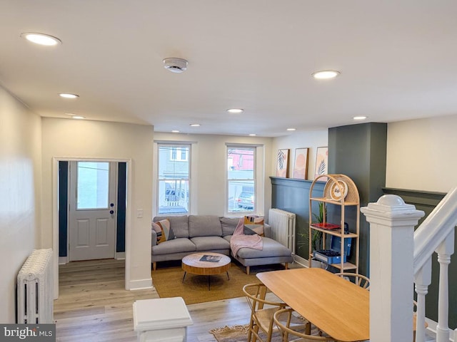 living room with light wood-type flooring, radiator heating unit, and recessed lighting