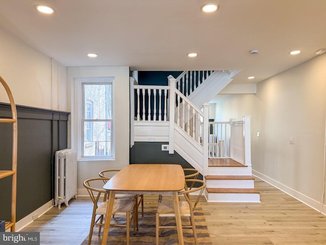 dining space featuring radiator heating unit, wood finished floors, and recessed lighting