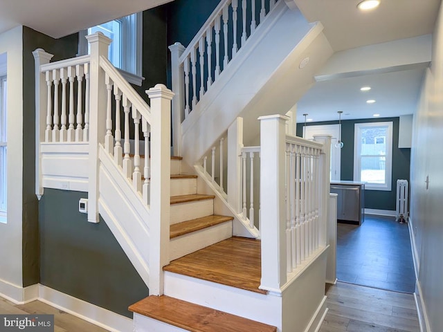 stairs featuring decorative columns, recessed lighting, wood-type flooring, radiator heating unit, and baseboards