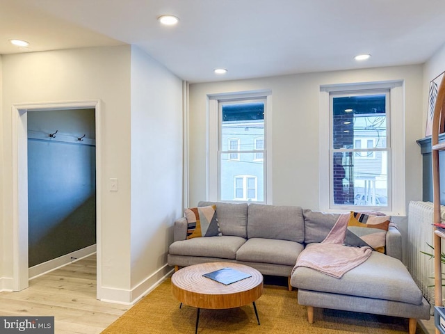 living area featuring light wood-type flooring, a wealth of natural light, baseboards, and recessed lighting