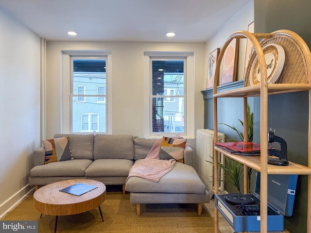 living area with recessed lighting, plenty of natural light, and baseboards