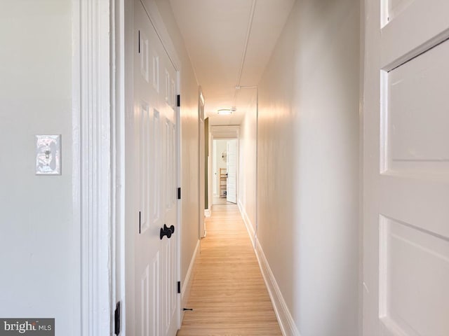 hallway with light wood finished floors and baseboards