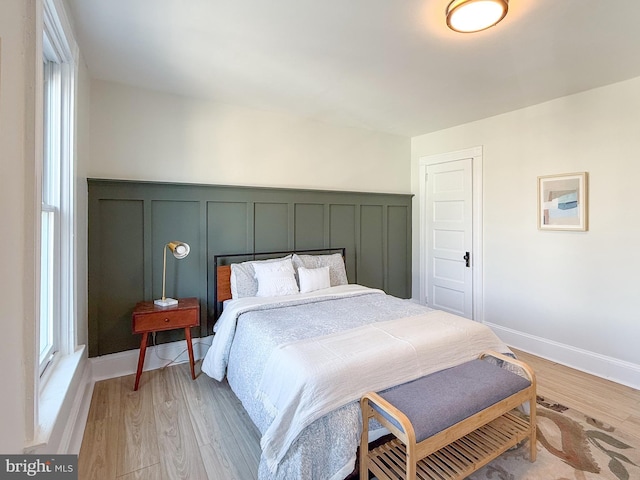 bedroom with light wood finished floors and baseboards