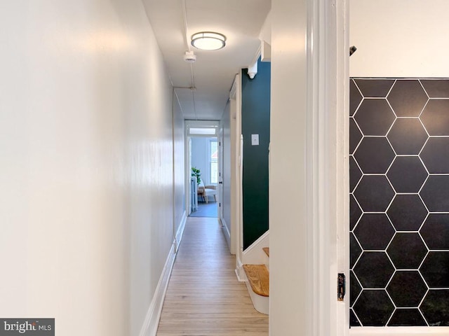 hallway with baseboards and wood finished floors