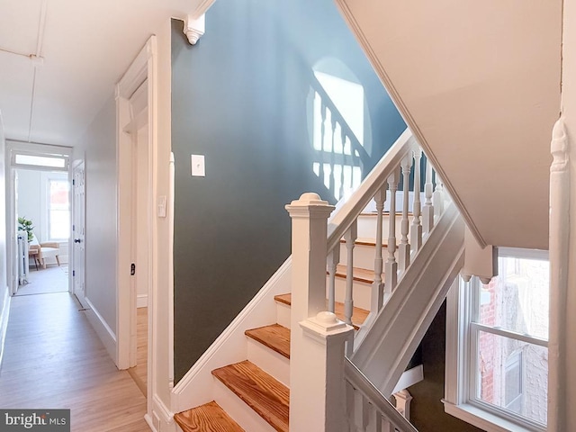 staircase featuring baseboards and wood finished floors