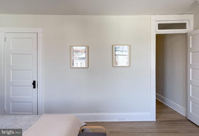 bedroom with baseboards and wood finished floors