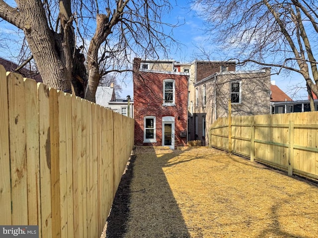 back of property featuring a fenced backyard and brick siding