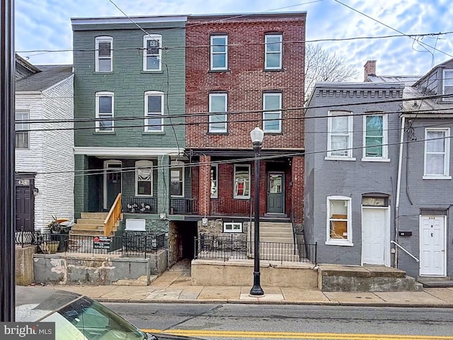 townhome / multi-family property featuring brick siding and a fenced front yard