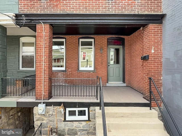 doorway to property featuring brick siding