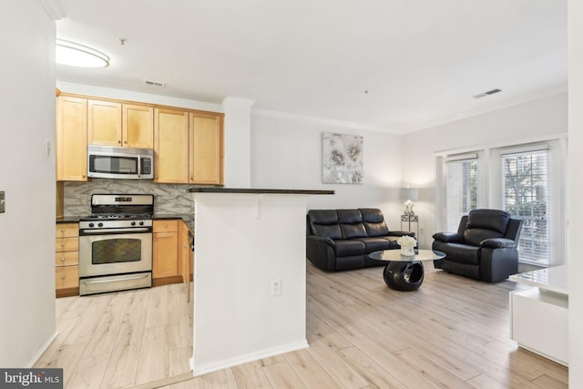 kitchen with stainless steel appliances, dark countertops, open floor plan, and a breakfast bar