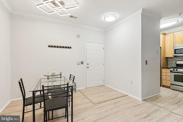 dining area with visible vents, crown molding, and light wood finished floors