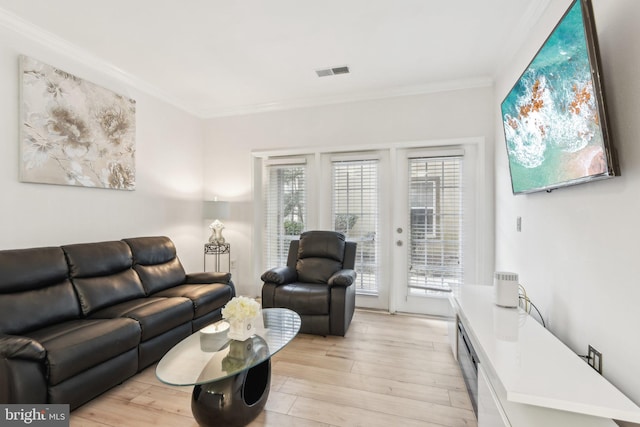 living area featuring ornamental molding, light wood-type flooring, and visible vents