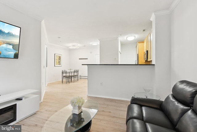 living room featuring ornamental molding, light wood finished floors, visible vents, and baseboards