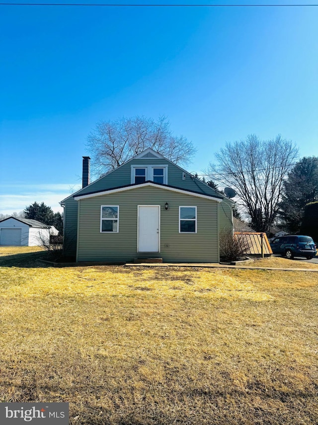 view of front of house with a chimney and a front lawn