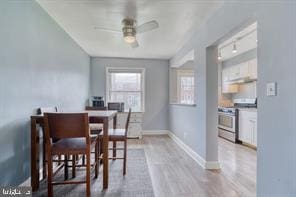 dining area featuring a ceiling fan, light wood-type flooring, and baseboards