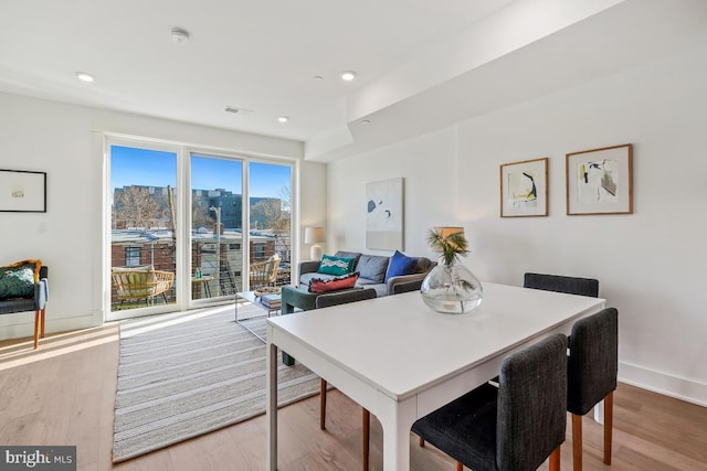 dining space featuring baseboards, visible vents, light wood-style flooring, and recessed lighting