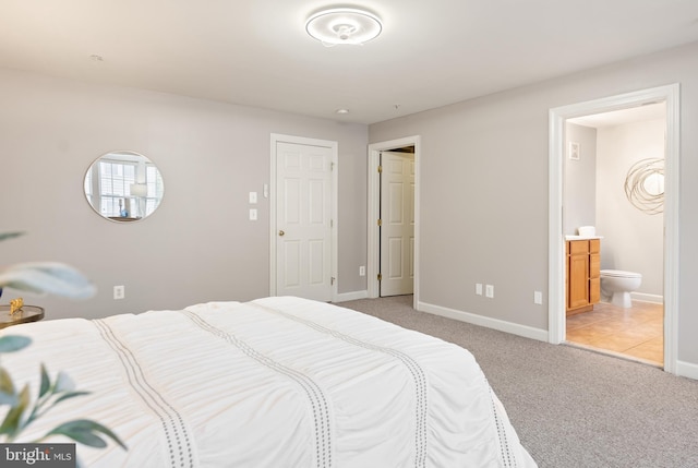 bedroom featuring light carpet, baseboards, and ensuite bathroom