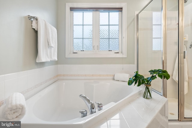 bathroom with a stall shower and a bath