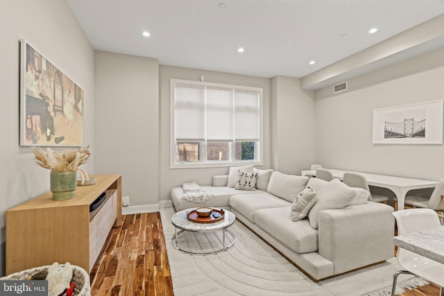 living room featuring recessed lighting, visible vents, baseboards, and wood finished floors