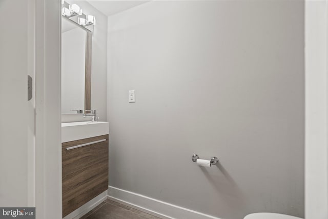 half bath featuring vanity and baseboards