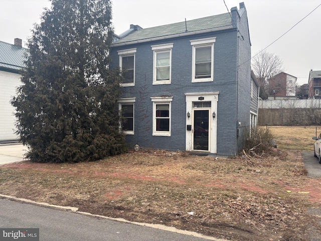 view of front of home with brick siding and a chimney