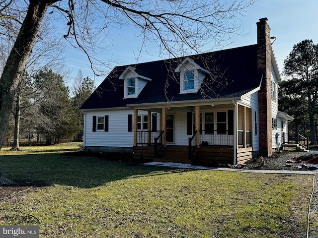 cape cod house featuring covered porch, a chimney, and a front yard