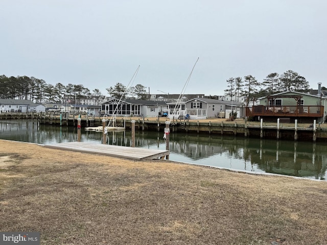 view of dock featuring a residential view, a water view, and a yard