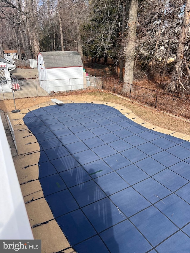 view of pool with a shed, fence, a fenced in pool, and an outdoor structure