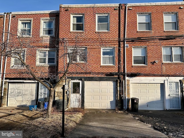 view of front facade featuring a garage, brick siding, and driveway