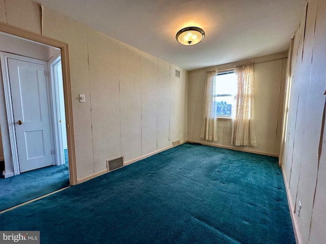 unfurnished bedroom with visible vents, carpet flooring, and a decorative wall