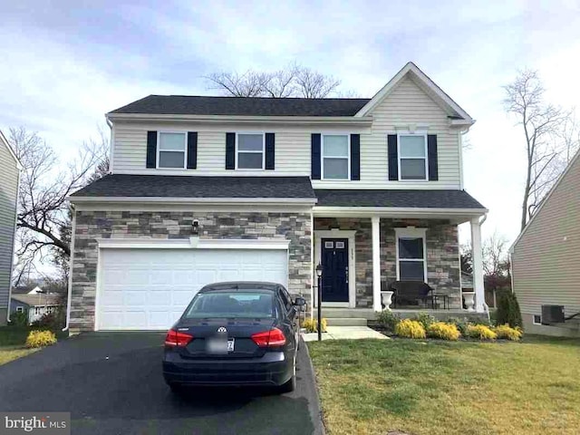 view of front of property with aphalt driveway, an attached garage, covered porch, stone siding, and a front yard