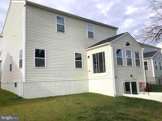 rear view of house featuring a lawn