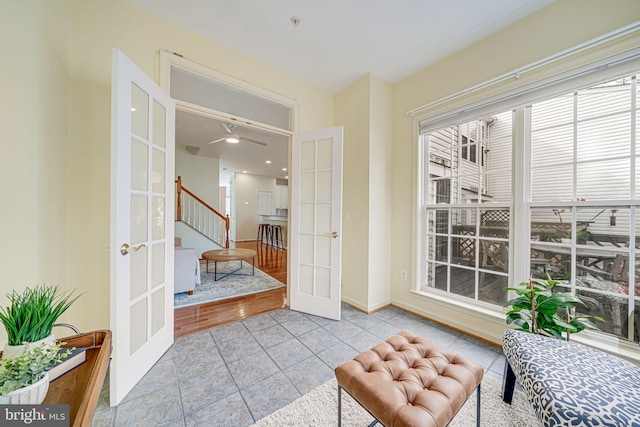 living area with light tile patterned floors, stairs, and french doors