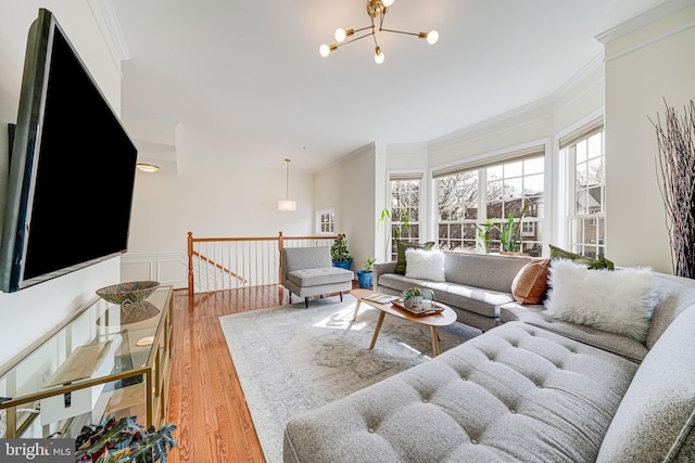 living room featuring a notable chandelier, wainscoting, wood finished floors, and crown molding