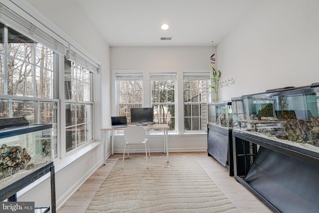 office space featuring light wood-style floors, baseboards, and visible vents