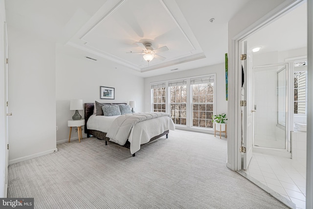 bedroom featuring light carpet, multiple windows, baseboards, and a raised ceiling