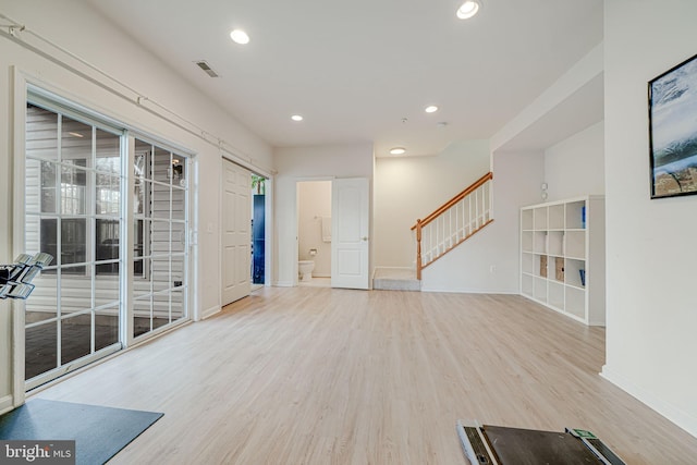 unfurnished living room featuring baseboards, visible vents, stairway, light wood-type flooring, and recessed lighting