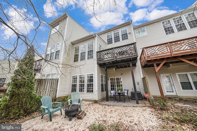 back of property featuring central AC unit, a patio area, fence, and a fire pit