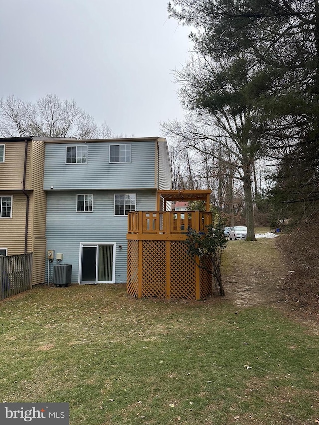 rear view of property with fence, central AC unit, a lawn, and a wooden deck