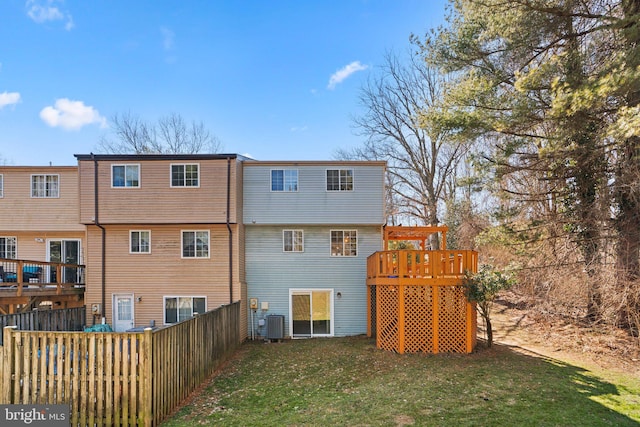 rear view of house featuring central air condition unit, a deck, and a lawn