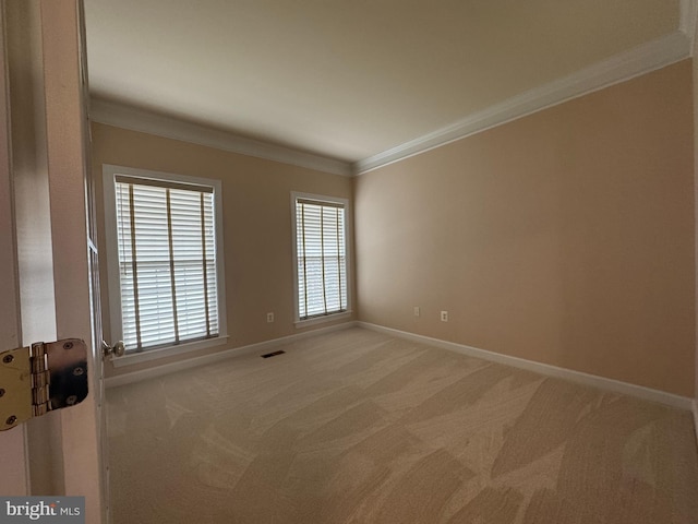 unfurnished room with baseboards, light carpet, visible vents, and crown molding