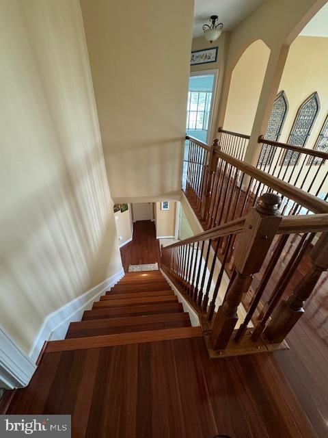 stairs with baseboards and wood finished floors