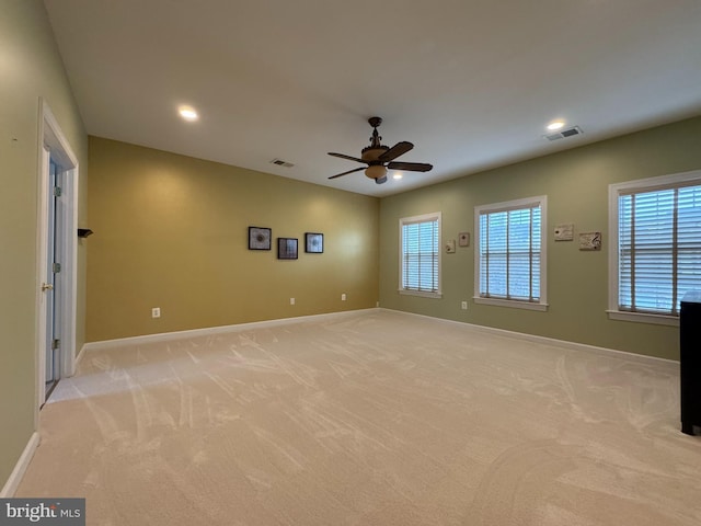 empty room featuring visible vents, baseboards, and light carpet