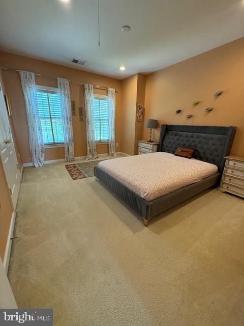 carpeted bedroom with visible vents and baseboards